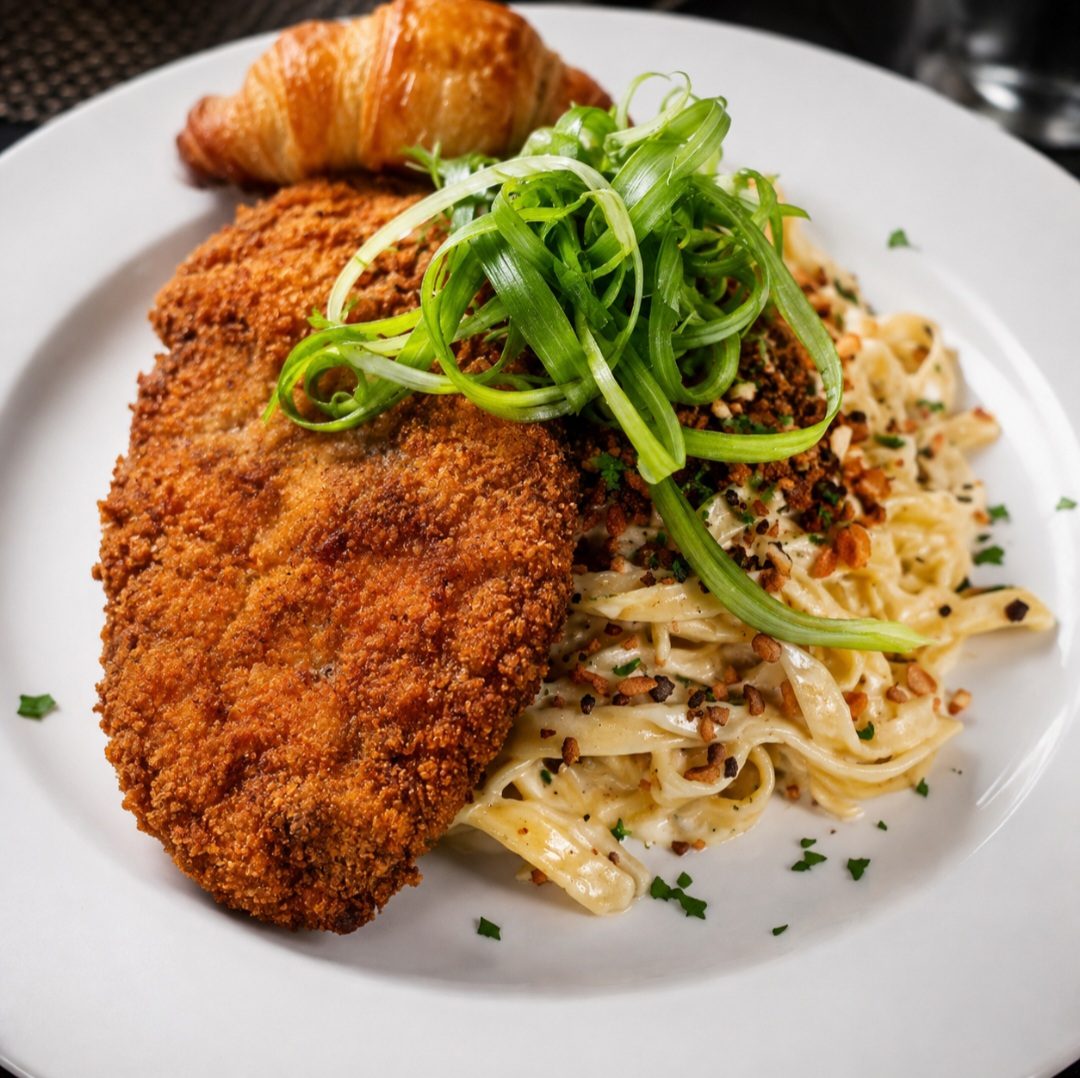 Breaded chicken cutlet over creamy fettuccine